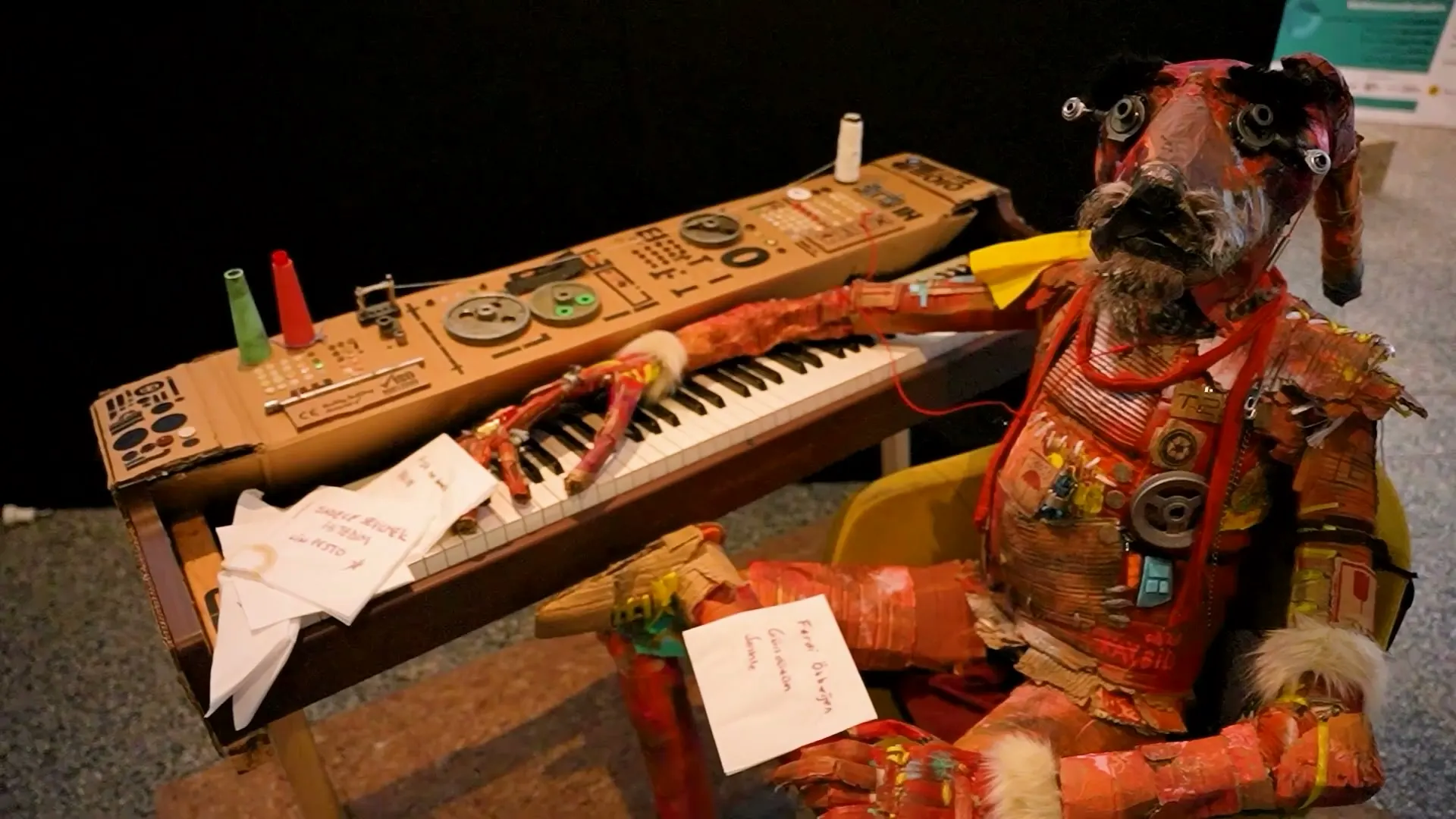Atık piyano parçalarından yapılmış, synthesizer başında aslan figürlü heykel